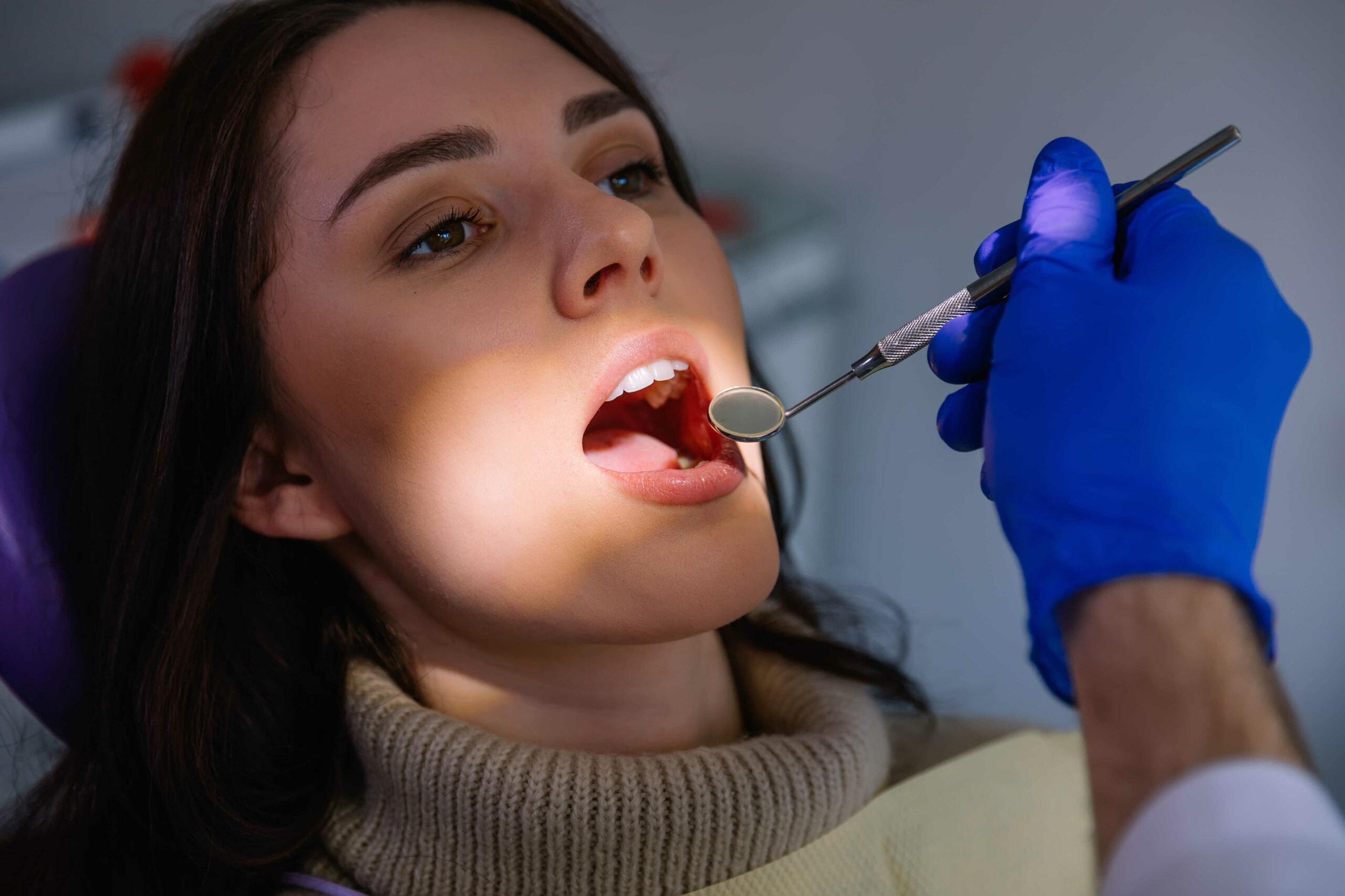 The patient is sitting in a dental chair with her mouth open professional dentist treat the teeth of woman patient in clinic in Chicago