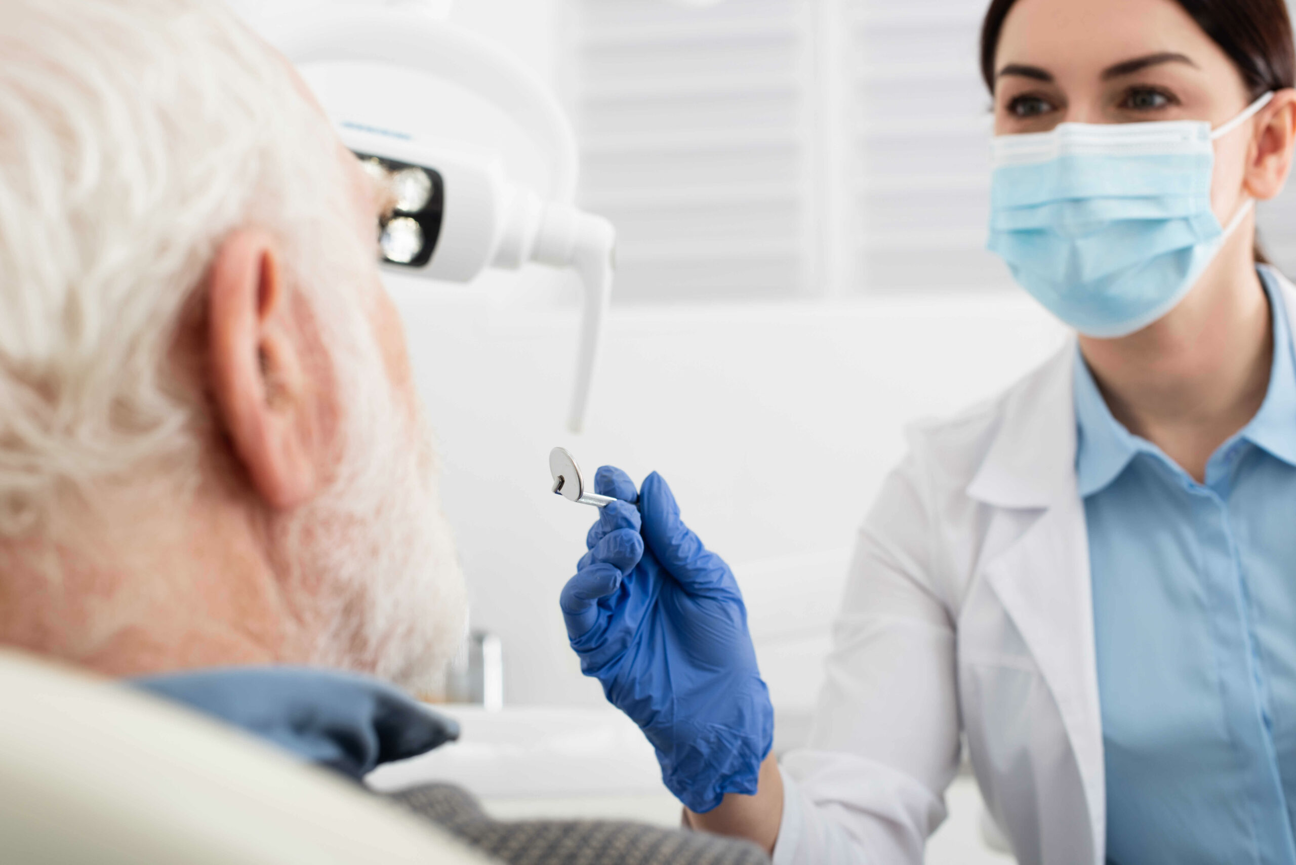 senior-man-having-teeth-examination-by-dentist-in-latex-gloves-with-mirror-in-clinic-in-chicago